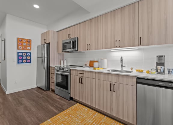 a kitchen with wooden cabinets and stainless steel appliances and a yellow rug