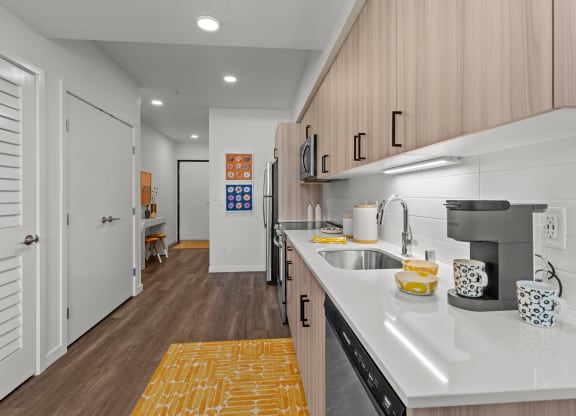 a kitchen with white countertops and a stainless steel sink