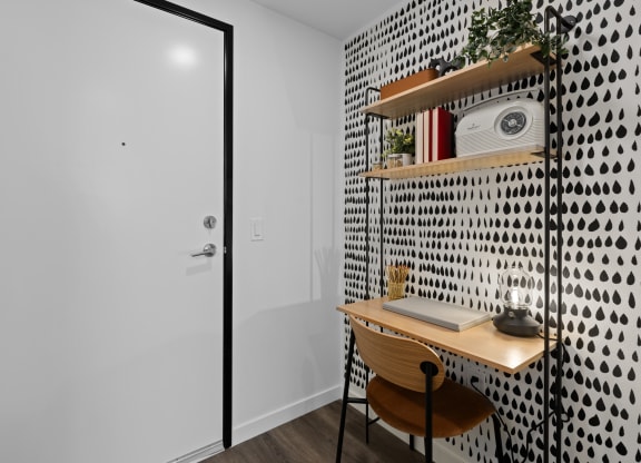 a small desk in a room with a white wall and a door