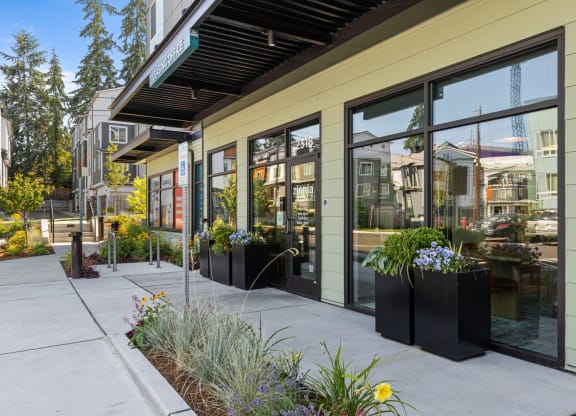 a sidewalk in front of a building with large glass windows
