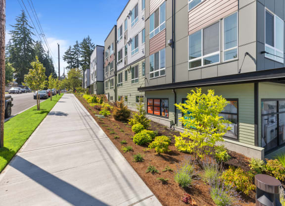 new apartment buildings on the side of a sidewalk
