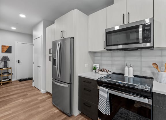 Gridline Apartments Kitchen with Stainless Steel Fridge and Entryway