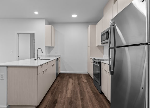 a renovated kitchen with white cabinets and stainless steel appliances