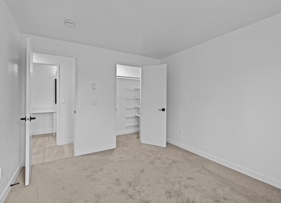 an empty bedroom with white walls and a closet