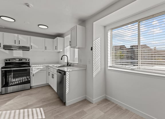 a kitchen with a large window and a stove and sink