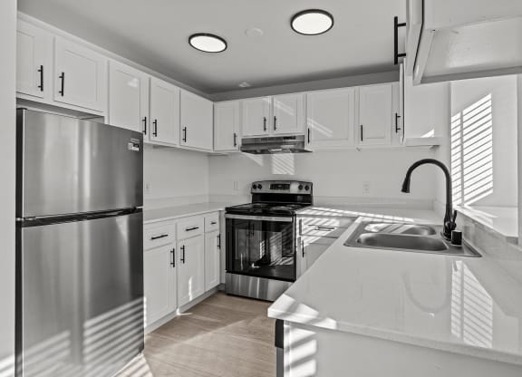 a kitchen with white cabinets and stainless steel appliances