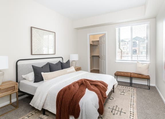 a bedroom with a bed and two windows