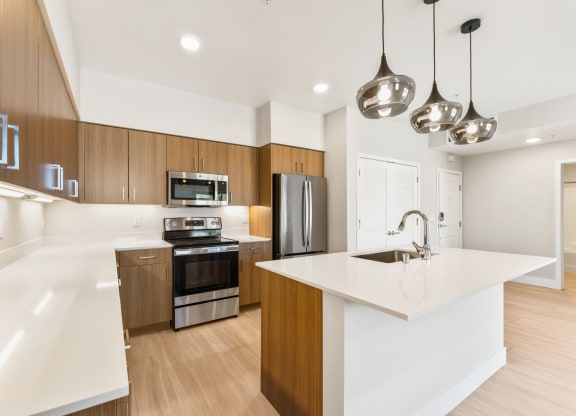 a white kitchen with wooden cabinets and stainless steel appliances