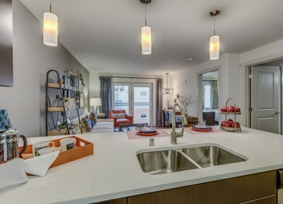 a kitchen with a sink and a view into a living room