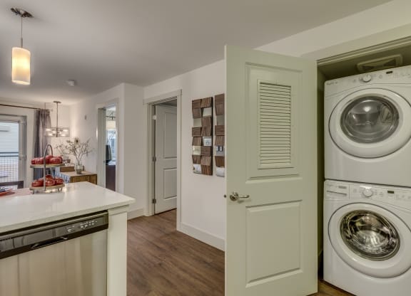 a washer and dryer in a kitchen with a door to the laundry room