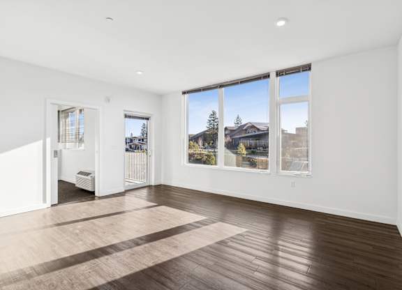 A large empty room with a view of the outside through the windows.