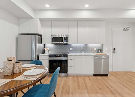 OnyxOnPark_SanDiego_CA_Model_1BR__A modern kitchen with a dining table set for two.