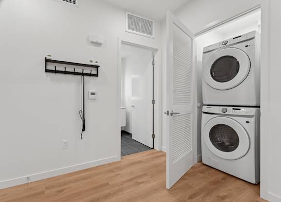 OnyxOnPark_SanDiego_CA_Model_1BR_ A laundry room with a washer and dryer.