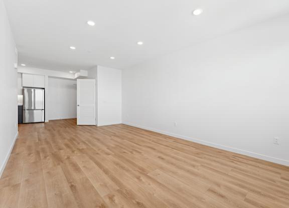 OnyxOnPark_SanDiego_CA_Vacant_2BR_ A room with wooden floors and white walls.