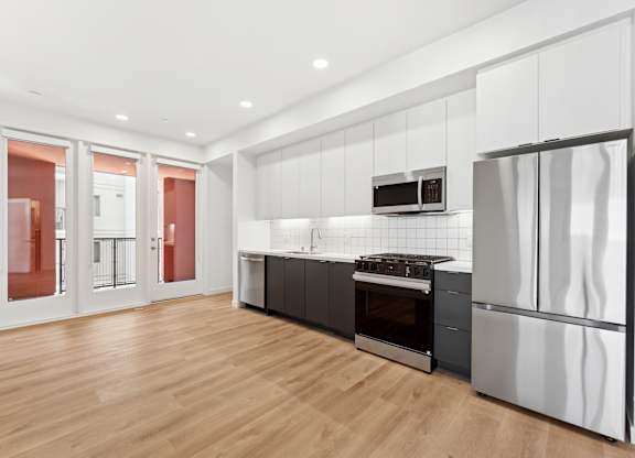 OnyxOnPark_SanDiego_CA_Vacant_2BR_ A modern kitchen with stainless steel appliances and wooden flooring.