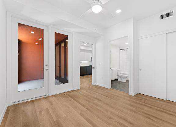OnyxOnPark_SanDiego_CA_Vacant_2BR_ A room with a wooden floor and white walls.