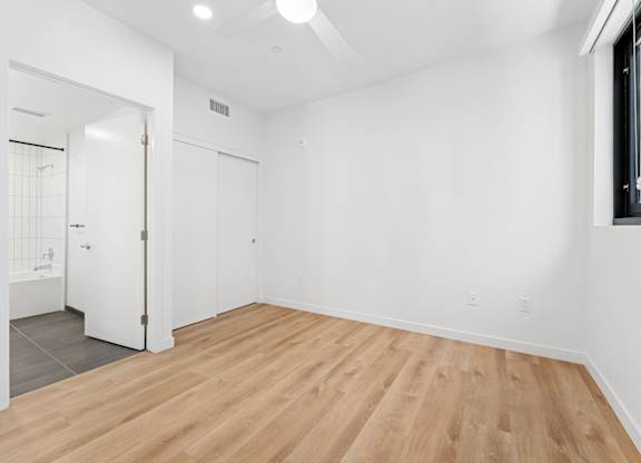 OnyxOnPark_SanDiego_CA_Vacant_2BR_ A room with wooden flooring and white walls.