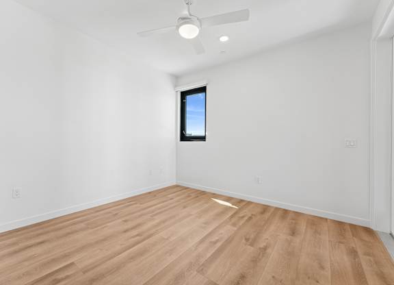 OnyxOnPark_SanDiego_CA_Vacant_2BR_B1_A room with a wooden floor and a ceiling fan.