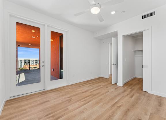 OnyxOnPark_SanDiego_CA_Vacant_2BR_B1_A room with a ceiling fan and a door leading outside.