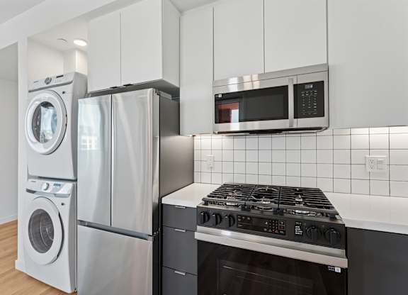 OnyxOnPark_SanDiego_CA_Vacant_2BR_B1_A modern kitchen with a stove, oven, and microwave.
