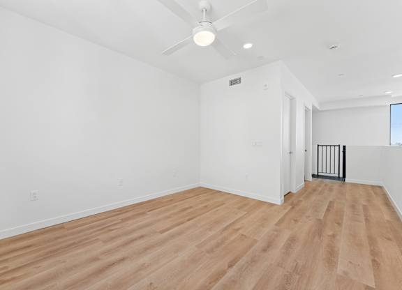 OnyxOnPark_SanDiego_CA_Vacant_Penthouse_A_A room with wooden flooring and white walls.