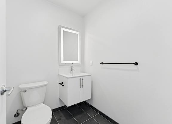OnyxOnPark_SanDiego_CA_Vacant_Penthouse_A_OnyxOnPark_SanDiego_CA_Vacant_Penthouse_A_A white toilet sits next to a sink in a small bathroom.