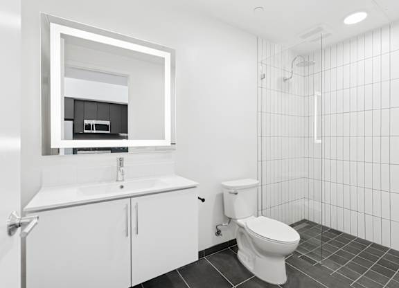OnyxOnPark_SanDiego_CA_Vacant_Penthouse_A_OnyxOnPark_SanDiego_CA_Vacant_Penthouse_A_A white bathroom with a toilet, sink, and mirror.