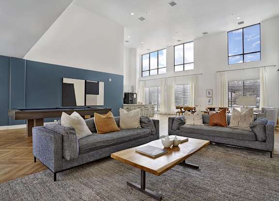 Alvera at the Meadows community lounge with blue sofas and coffee table