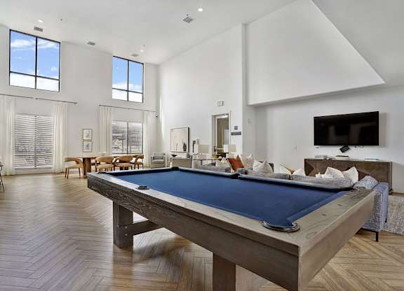 Alvera at the Meadows  A pool table is in the middle of a room with a lot of windows.