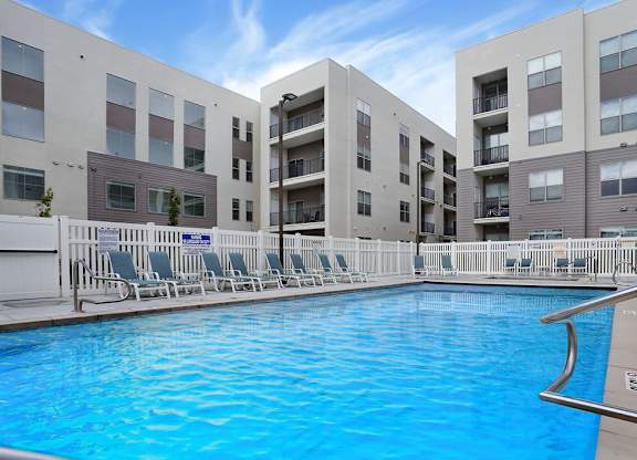 Alvera at the Meadows  swimming pool in front of apartment buildings.