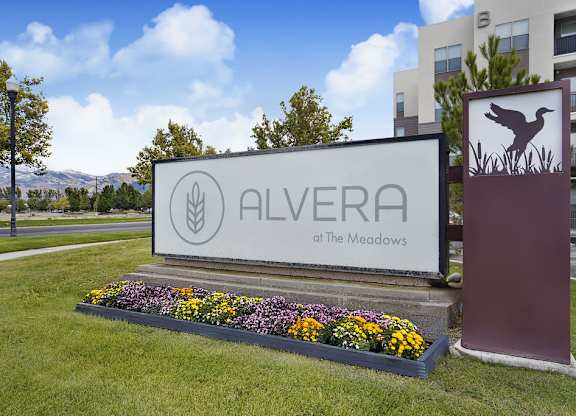 A sign for Alvera at The Meadows is surrounded by flowers.