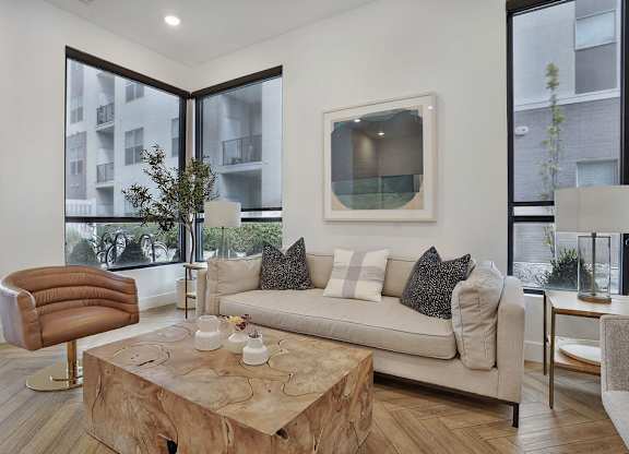 Alvera at the Meadows living room with a brown leather chair and a wooden coffee table.