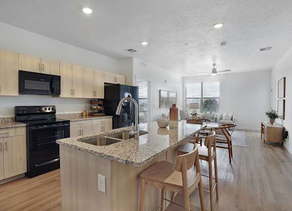 Alvera at the Meadows kitchen with wooden cabinets and a granite countertop.
