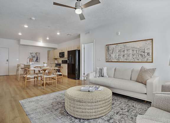 Alvera at the Meadows living room with a white couch, a round wicker coffee table, and a ceiling fan.