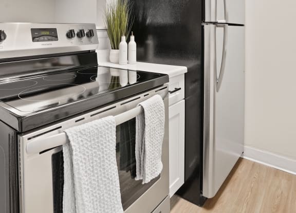 a renovated kitchen with white cabinets and stainless steel appliances and a refrigerator