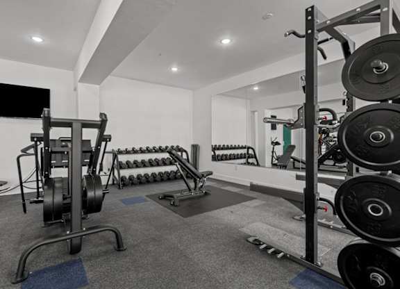 A black and white photo of a gym with weights and exercise equipment.