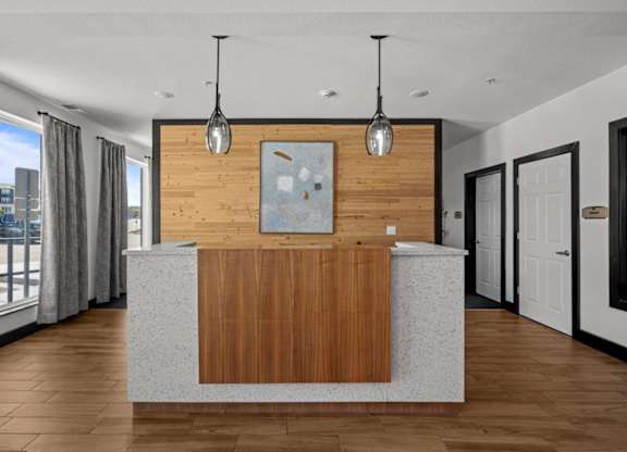 A reception area with a wooden panel and a grey counter.