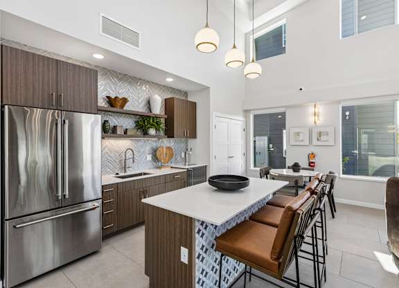 A modern kitchen with a large island and stainless steel appliances.