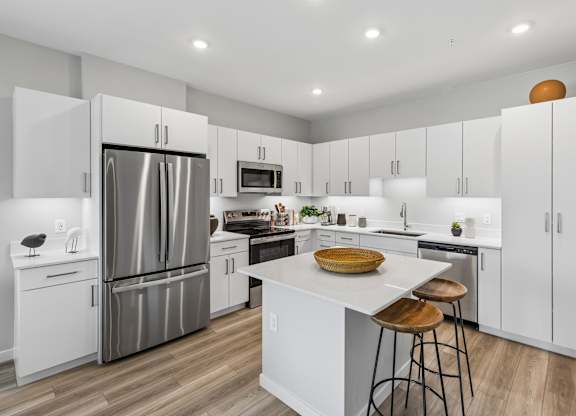 A modern kitchen with white cabinets and a central island.