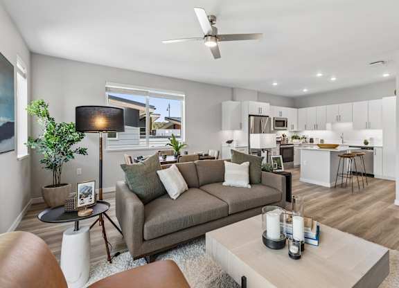 A living room with a grey couch and a brown leather chair.