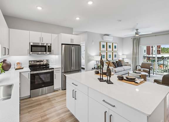 A modern kitchen with white cabinets and stainless steel appliances.