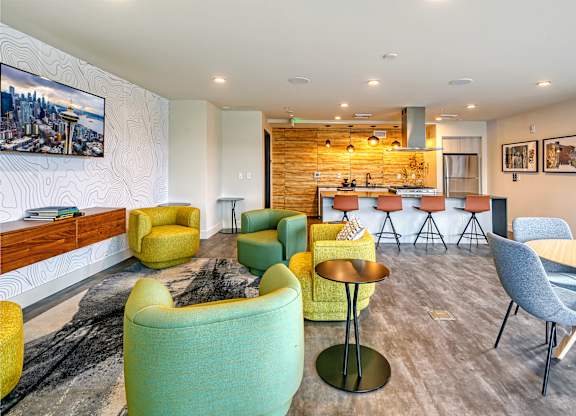 a living room with chairs and a bar and a kitchen