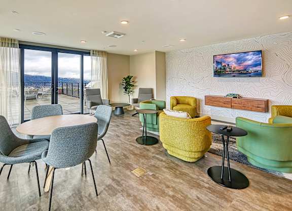 a living room with chairs and tables and a balcony