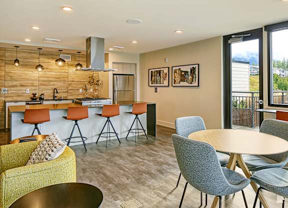 a community room with a kitchen and a table with chairs