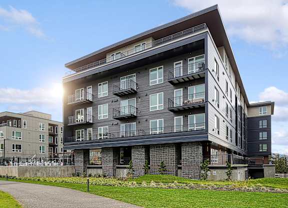 a large apartment building with a sidewalk in front of it