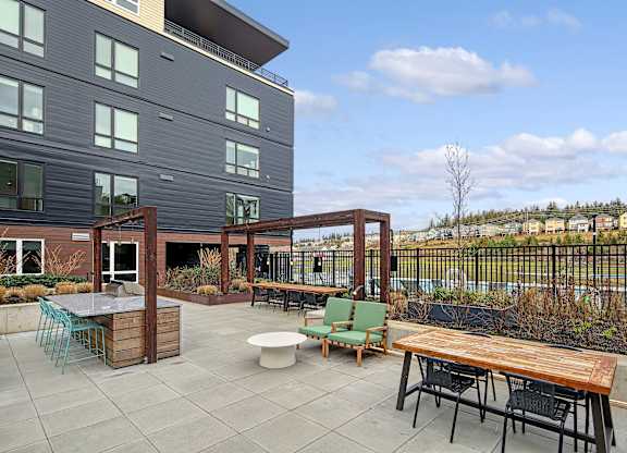 a patio with a table and chairs in front of a building