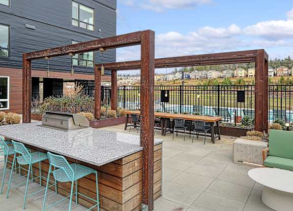 a patio with a bar and tables with chairs