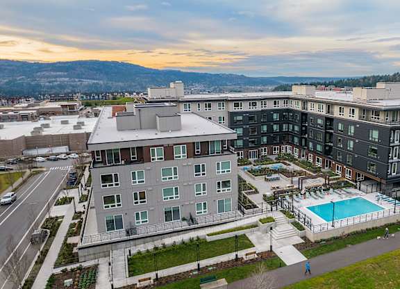 an aerial view of a large apartment building with a swimming pool