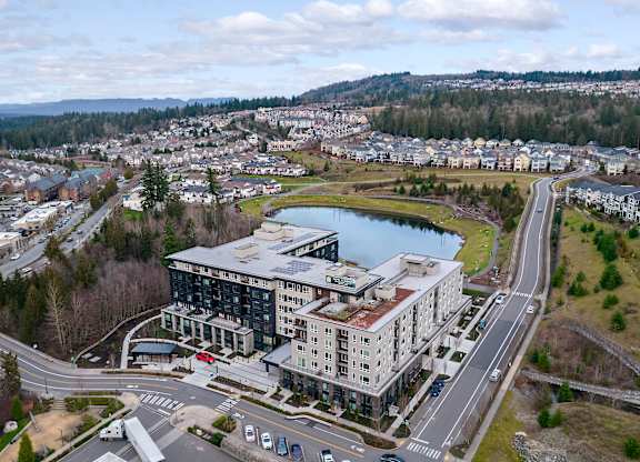 an aerial view of a building next to a lake