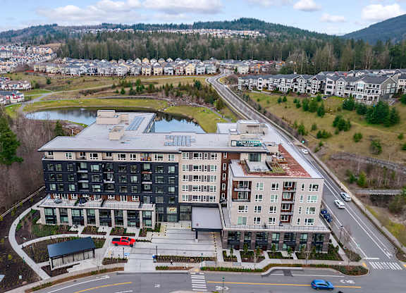 an aerial view of a building next to a road and a river